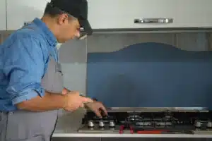 Técnico realizando conversão de fogão de GLP para gás natural